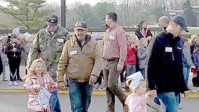 Two Students from Cedar Mountain walk proudly with their Veteran family members.