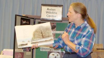 Avian expert Giselle Smisko of the Avian Wildlife Center reads the story Owl Moon to an interested group at the library.