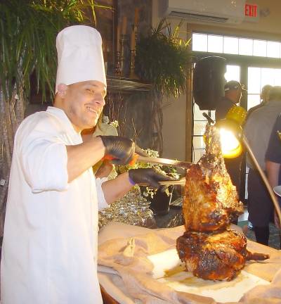 A Ballyowen food &amp; beverage staffer Joslyn carves a piece of delicious meat for a golfer