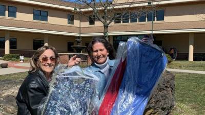 Prom items coordinator Marie Flores, left, and Woman’s Club member Dee Garbarino drop off prom dresses at Project Self-Sufficiency. (Photo courtesy of Marie Flores)