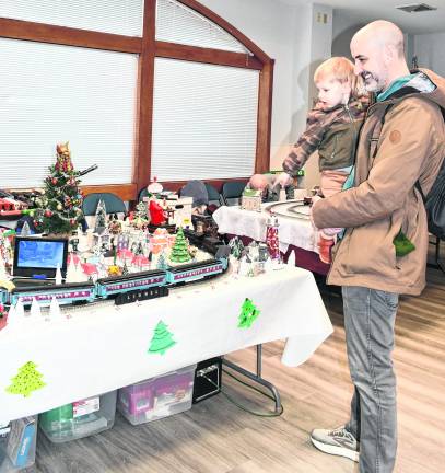 <b>Coyote and his father, Mike, Moeller of Lake Hopatcong look at a train display.</b>
