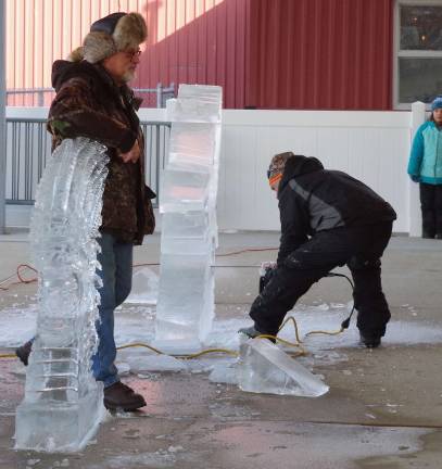 With chainsaw in hand, sculptor Neil Trimper shows the audience how it is done.