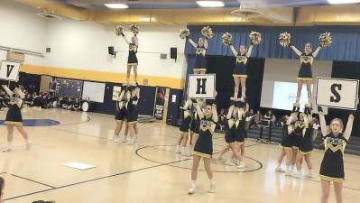 The cheer team performs sideline cheer.