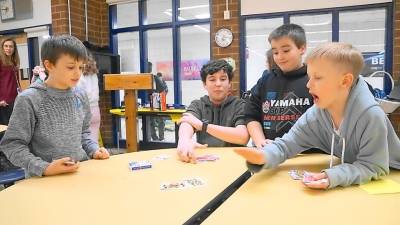 Students play the War card game.