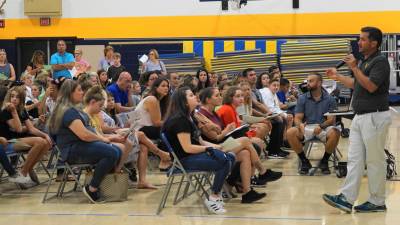 Physical Education Teacher Kieran Killen speaks with parents and students