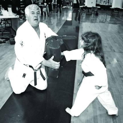 Sensei Shull absorbs a punch from one of his smallest students, blue belt Sophia Vigiletti.