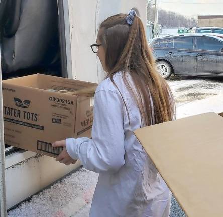Kylie Bork, a sophomore from High Point, is the first to load a box during the “Fill the Bus” event.