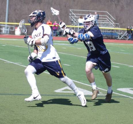 Vernon's Zack Biango carries the ball as Pope John's Keith Johnson closes in from behind.