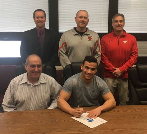High Point's Jake Philip, seated with father Steven, will continue his football career next season at Salisbury University. Looking on in the back row from left to right are: Principal Jon Tallamy, Head Football Coach Jim Delaney, and Athletic Director Todd Van Orden.