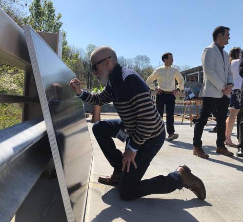 Vincent Senia, chief actuary at Selective Insurance, signs a solar panel commemorating the completion of solar installations at the company’s Branchville headquarters at its Power Up NJ event April 21. (Photos provided)