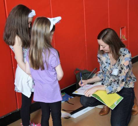 Author and illustrator Sarah Williamson autographs her book.