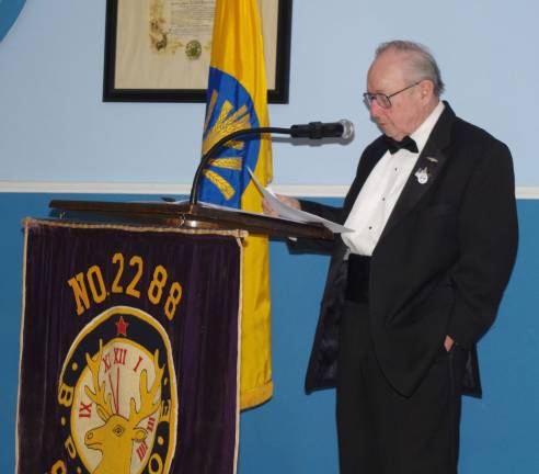 Jim &quot;Stogie&quot; Adams, a Sussex Elks Trustee and 10-year veteran of the United States Navy Submarine Service explains the meaning of the empty table that honors those military personnel who remain prisoners of war.