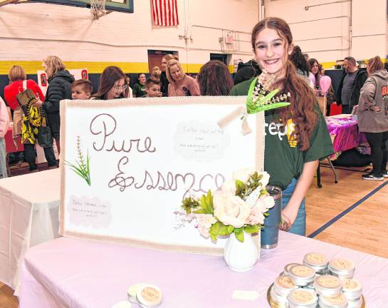 <b>Ayla Mancini stands at her Pure Essence table.</b>