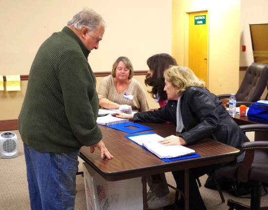 PHOTO BY CHRIS WYMAN At the municipal building, incumbent Vernon Township Councilman Dan Kadish waits for a poll worker to locate a pen so that he can sign in and proceed to cast his ballot. In Vernon, poll workers reported that voter turnout was quite good with a steady stream of voters coming in to cast their ballots.
