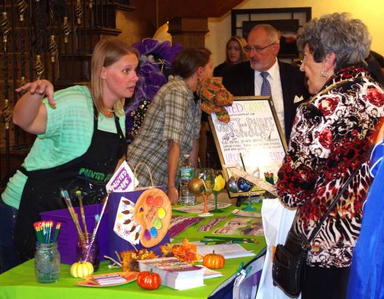 PHOTOS BY CHRIS WYMAN Vernon resident Beckie Sajban of HardystonþÄôs Painted Grape Craft and Paint Studio tells interested visitors about what her business has to offer. at the Sussex County Chamber of Commerce's 23rd annual business expo on Oct. 19.