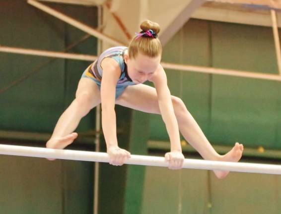 Gymnast Moya Lynch of Wantage, New Jersey performs on the uneven bars.