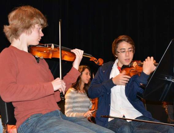 VTHS Orchestra Senior Christopher Kohama (right) and 8th grader David MacMillan discuss shifting techniques on the violin.
