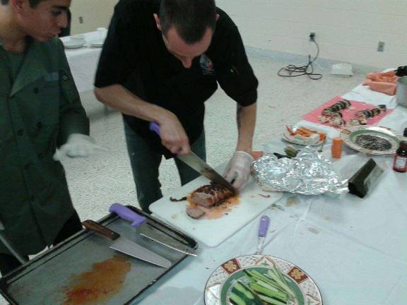 Smokey’s Chef Vinnie Jurczyszyn shows student Jon Soto how to slice a tenderloin.