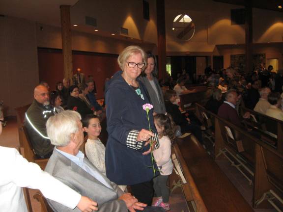 Bea Harrigan receives her carnation at St. Francis de Sales' Mother's Day celebration.