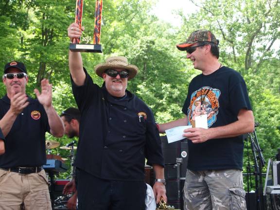 Photo courtesy Russ Mensch/Mensch &amp; Company, Inc. Chef Dan Lemire of Chumley’s BBQ &amp; Catering Company (center) celebrating his team’s first place victory. He is flanked by Jason Gaer of Chumley's BBQ on the left and Claude Jaillet of Franklin Sussex Auto Mall on right.