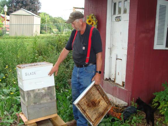 John demonstrates how he dissembles a hive to get an the honey bee inside.