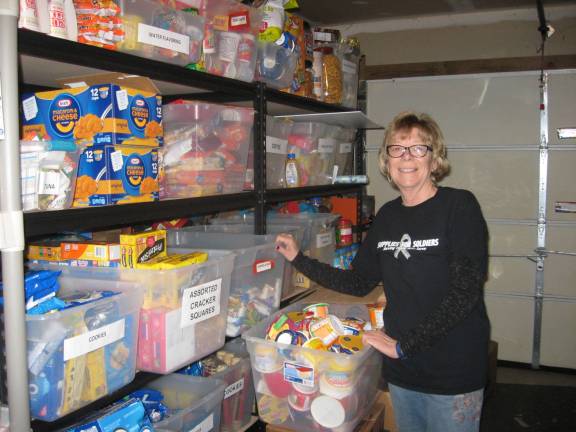 Nancy shows the many donated items stacked in the Wolfes&#x2019; garage.
