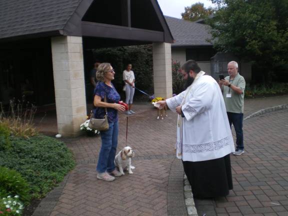 Marie Flores and her dog Mia receive a blessing from Father Chris Barkhausen.