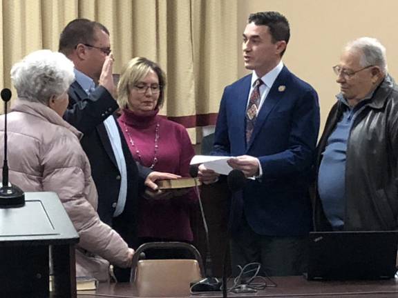 State Assemblyman Mike Inganamort, second from right, administers the oath of office to Bradley Sparta, who was re-elected to the Township Council in November. Holding the Bible is his wife, Robyn. Watching are his parents, Gary and Barbara. (Photos by Kathy Shwiff)