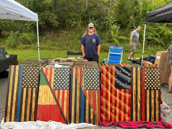 Ryan Locascio display the custom wooden flags that he makes at the street fair.