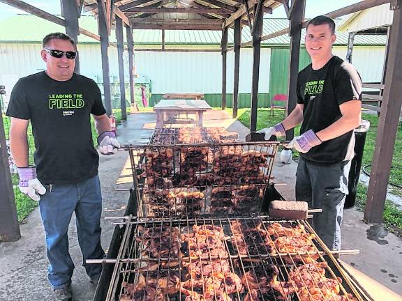 <b>Members of the Board of AG prepare and barbecue chicken.</b>