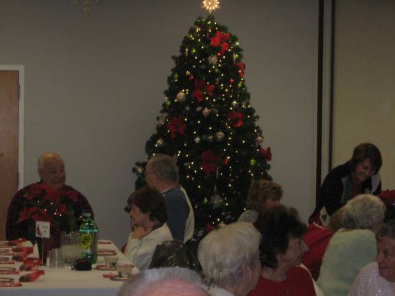 Seniors gather around the Christmas tree during their holiday party at the Vernon Senior Center.
