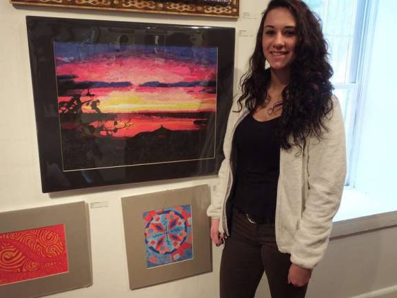 Wallkill Valley Regional High School 11th grader Arielle Stampone stands next to her &quot;Sunset&quot; landscape creation. The picture is made from old magazine paper.