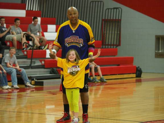 The Wizards' Claude "Tojo" Henderson with eight-year-old Madison Rokosny of Wantage. Henderson has been with the Wizards since 1965. He is a decorated Vietnam veteran and hails from Passaic.