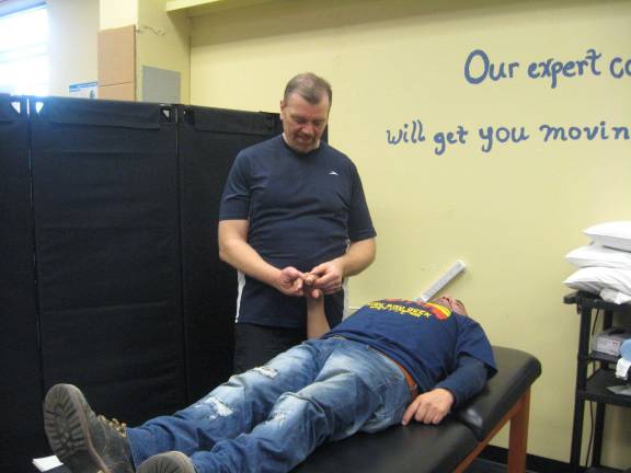 PHOTOS BY JANET REDYKE Physical therapist Christian Gartner assesses Edgar who had an on the job accident that required dry needling on a reconstructed finger.