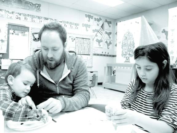Photo by Viktoria-Leigh Wagner Casey de Waal of Wantage helps his children, Sawyer, 3, and Ayyla, 6, at Literacy Night.
