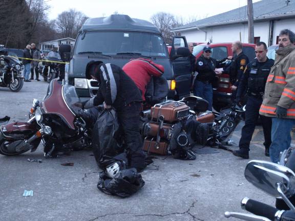 Photos by John Church The Ogdensburg Police and friends of the victims preparing to move the damaged motorcycles.