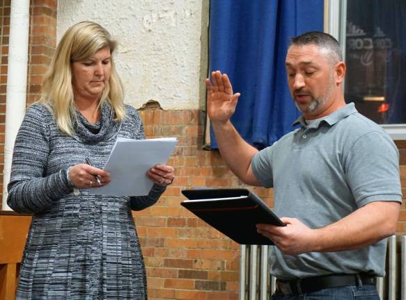 Photos by Vera Olinski Sussex-Wantage Board of Education Secretary Christina Riker, left, administers the oath of office to new school board member Ryan Coyle.