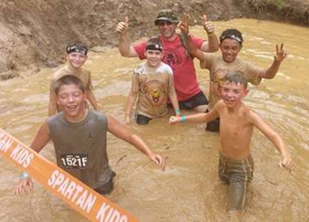 Tyler Hammerstedt, James Dorsey, Yorgo Liaros, Sensei Paul Doumanis, Ayden Alexander, and Andrew Miller are shown in the mud.