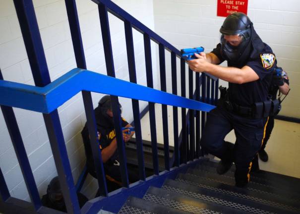 With weapons drawn, Vernon Township police officers are shown ascending a stairway at Lounsberry Hollow Middle School in a drill that includes scenarios of active shooter simulations.
