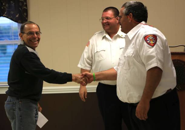 Lou Cecchini receives aaward for 40 years of service from Chief Jake Little and Assistant Chief Andrew Boutillette.