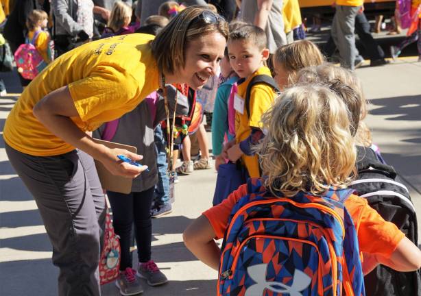 A Cedar Mountain teacher greets her students.