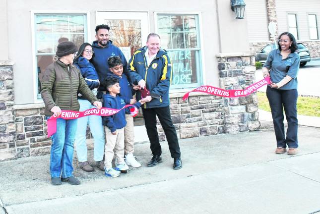 <b>Vernon Township Mayor Anthony Rossi cuts the ribbon with the owners of AQUAPURE on Saturday.</b>