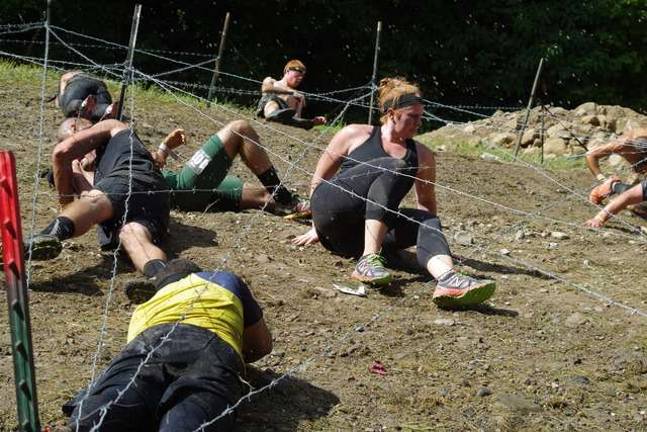 Crawling over the muddy ground under barbed wire.
