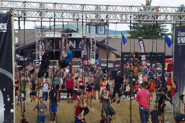 Rope climb with muddy water below.