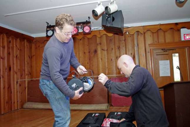 Highland Lakes residents Michael Gelfand (left) and Randy Staley are shown in the process of installing and testing a new set of high-end stage lights. The colorful lights are sound sensitive and are actuated and partially controlled by loud sounds and variations in volume.