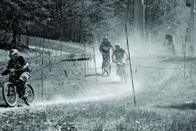 A wave of dust shrouded the trails as a long series of riders blasted down the trail.