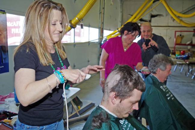 Mary Ayn Meidling of Roxbury's Nino's Expressions takes a little off the top for McAfee firefighter Tom O'Brien during Saturday's the St. Baldrick's Foundation fundraiser held at the Route 94 firehouse. It was O'Brien's first haircut in three or four months and it should last him a while.