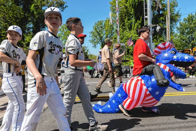 <b>Little League players and Boy Scouts march in the parade.</b>