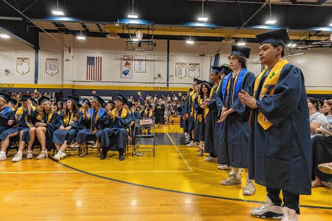 <b>Graduates line up to receive their diplomas.</b>