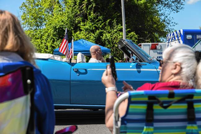 <b>A blue Camaro is driven in the parade.</b>
